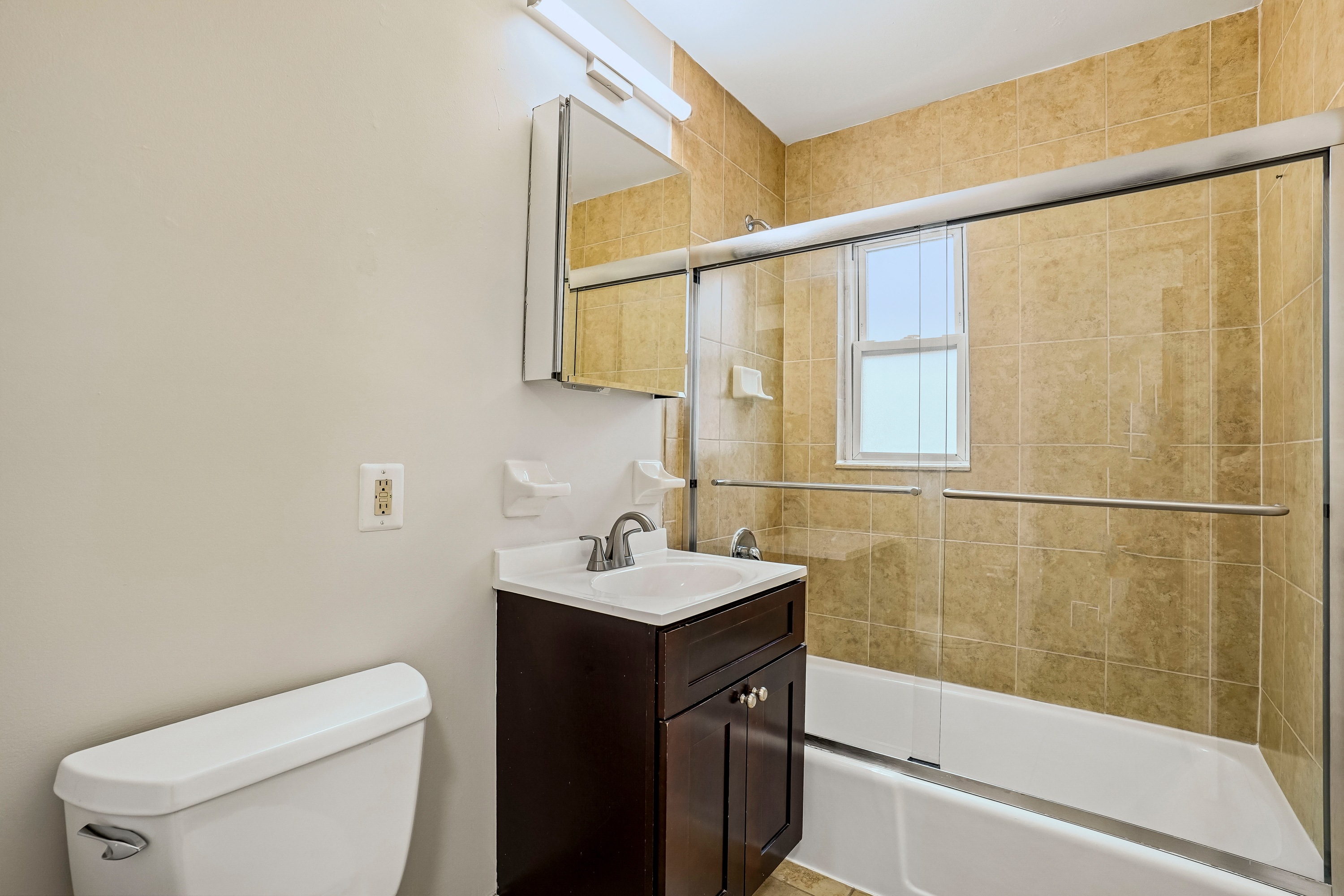 A bathroom with a toilet, sink, and bathtub.
